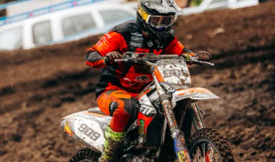 Piloto de motocross con el número 27 listo para salir a la pista