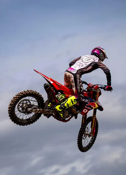 Piloto con moto roja en pleno salto contra el cielo de Amaguaña