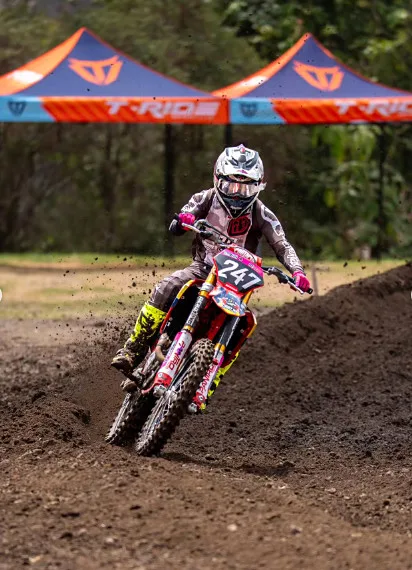 Piloto con la moto 247 frente a las carpas del evento