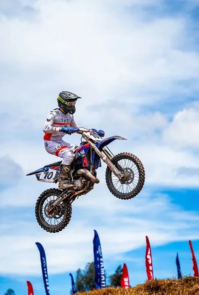 Piloto saltando frente a las banderas del campeonato