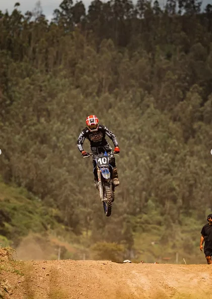 Salto de motocross entre los árboles de la pista